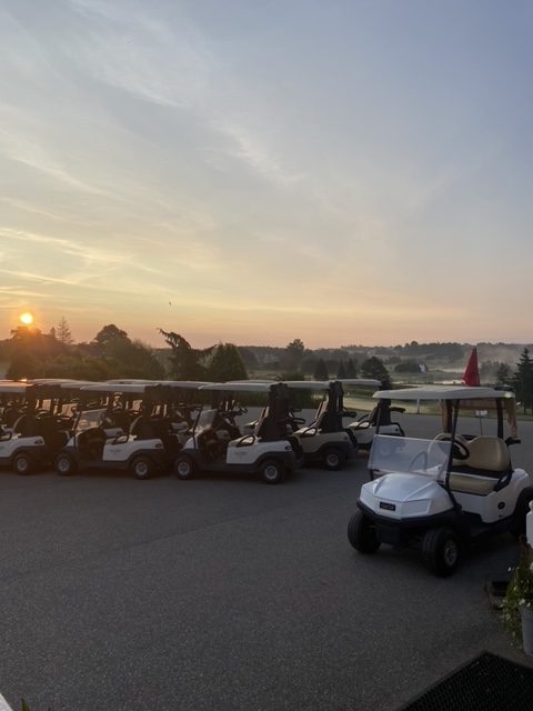 Carts on golf course at sunrise